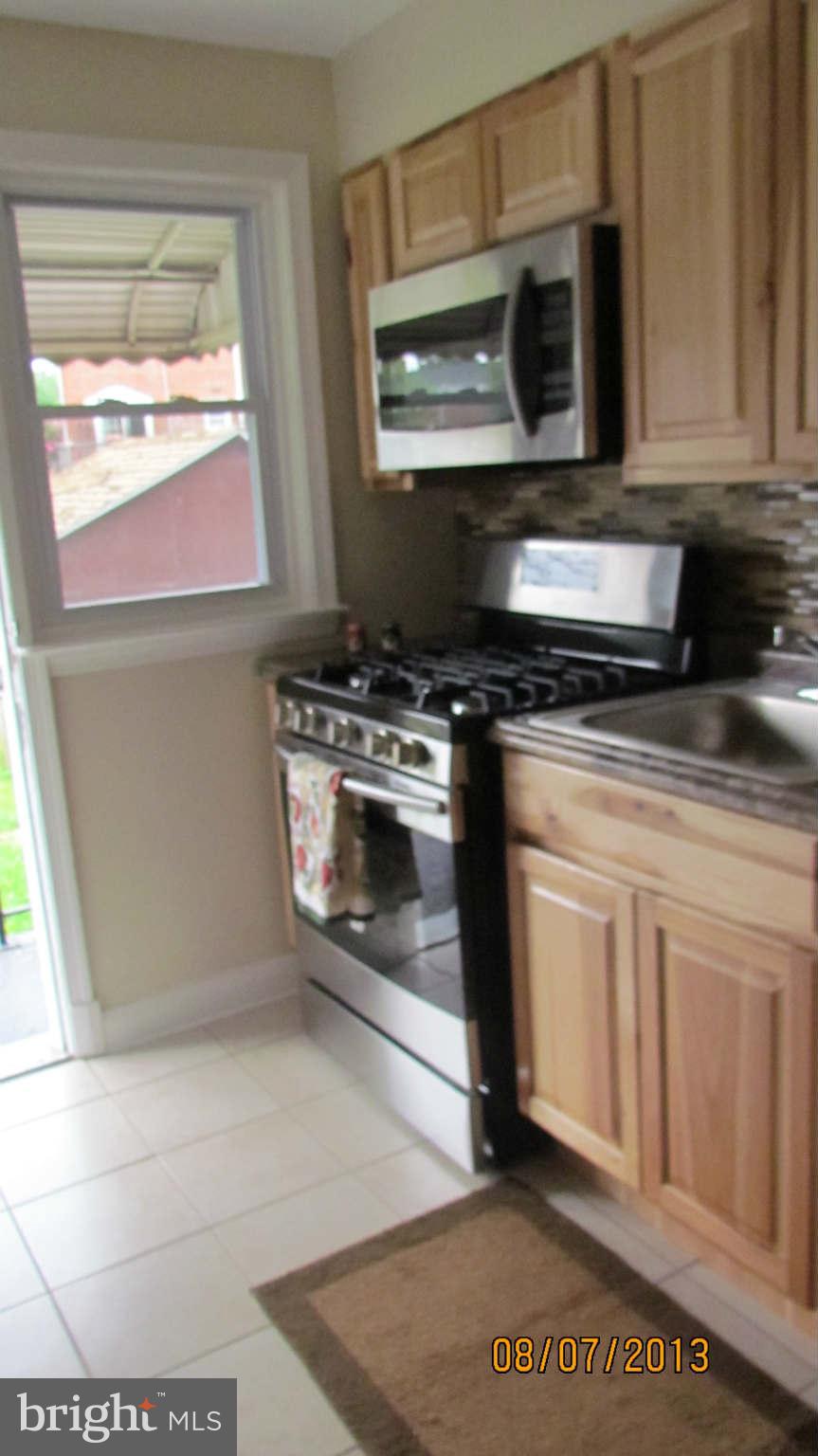2233 Searles Road Baltimore, MD 21222 - Photo 3 of 15 a kitchen with stainless steel appliances granite countertop a stove a microwave and a sink