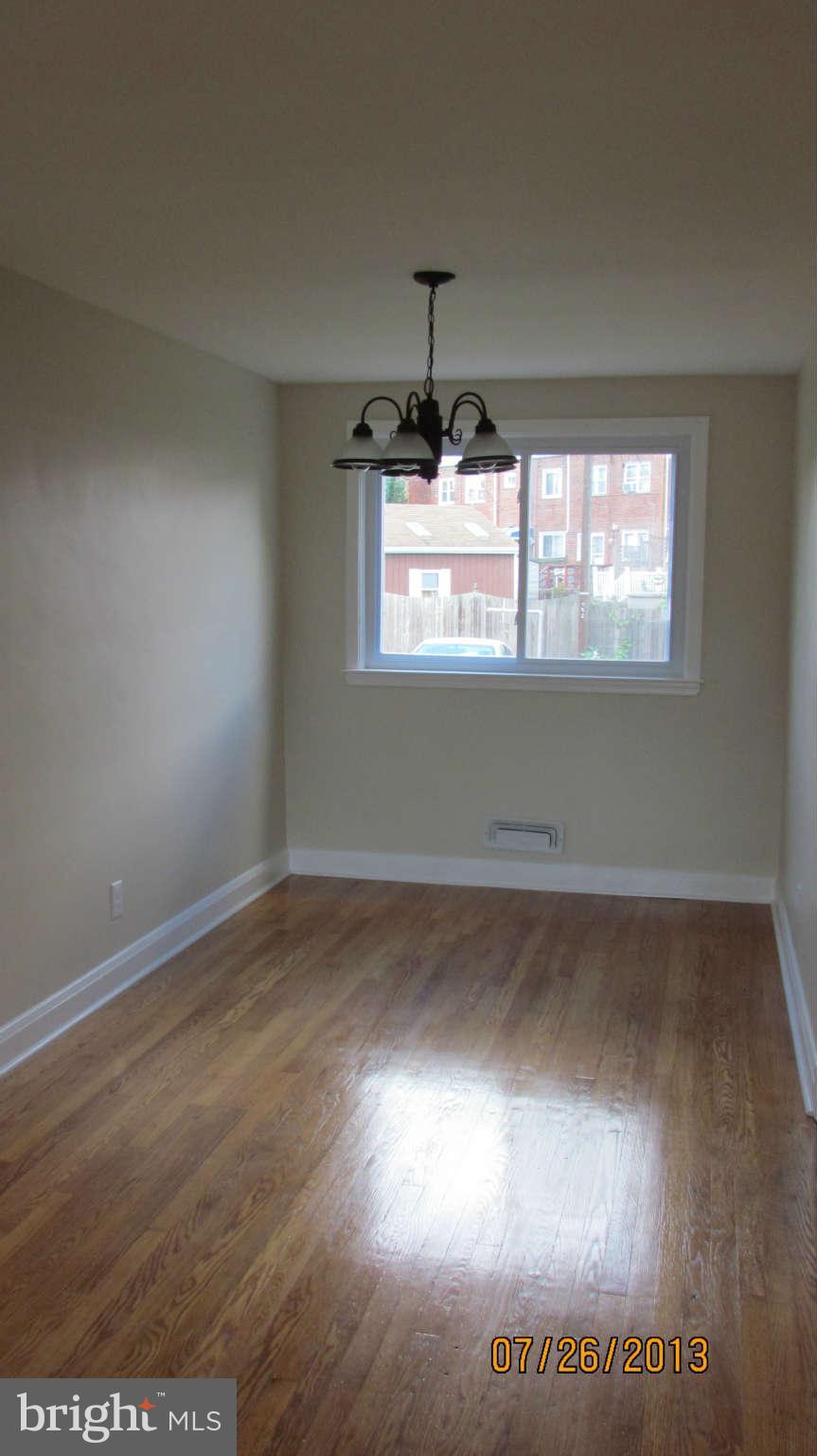 2233 Searles Road Baltimore, MD 21222 - Photo 5 of 15 an empty room with wooden floor and windows