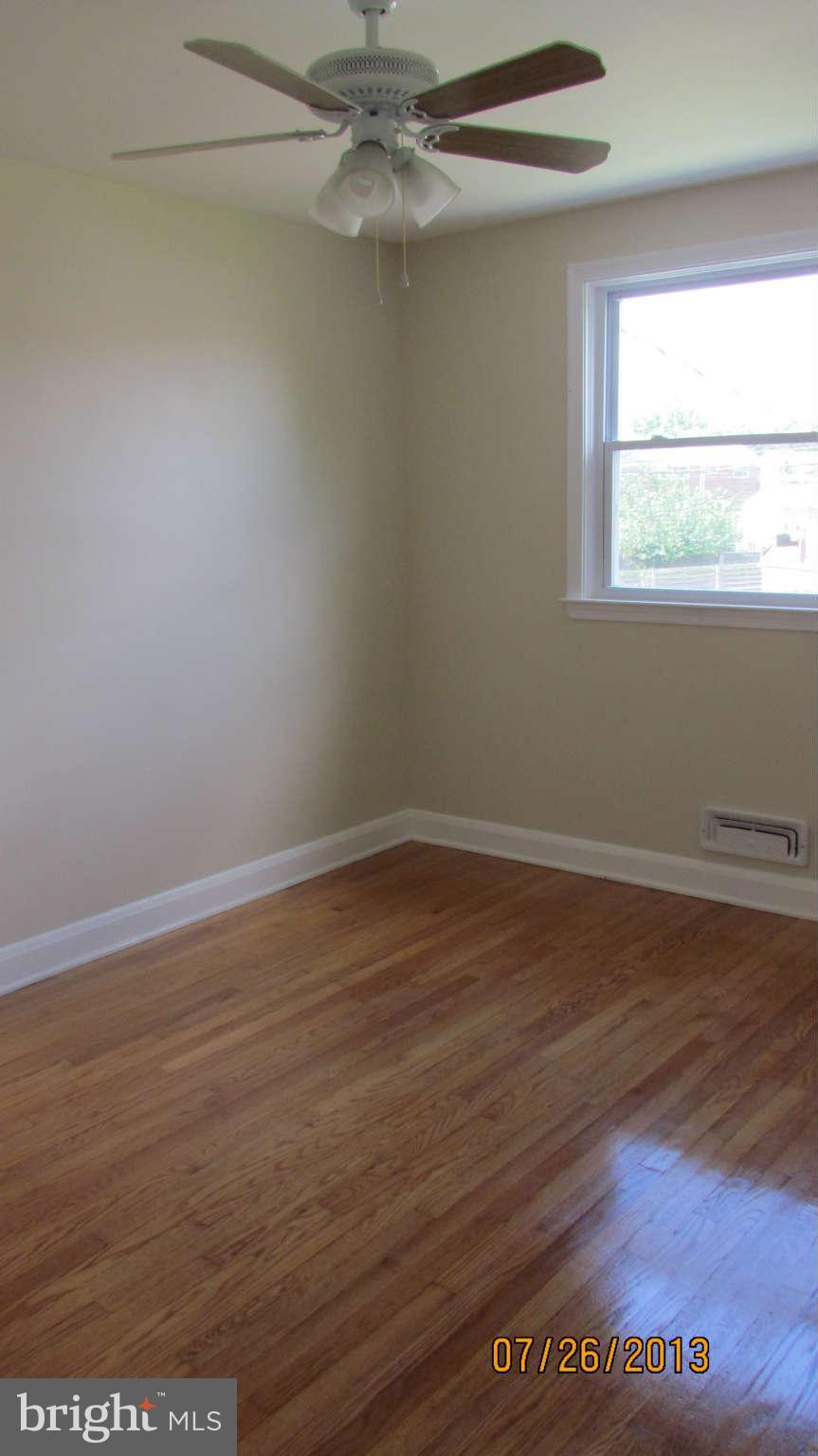 2233 Searles Road Baltimore, MD 21222 - Photo 7 of 15 a view of an empty room with wooden floor and a window