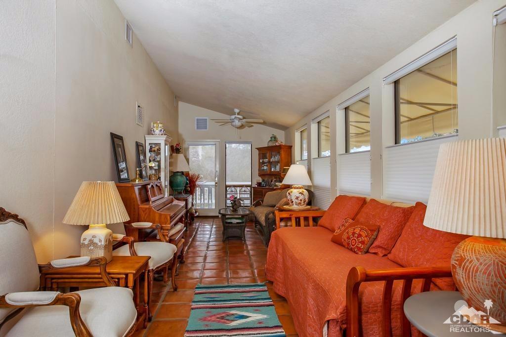 60189 Devils Ladder Road Mountain Center, CA 92561 - Photo 8 of 25 a living room with furniture a fireplace and a large window