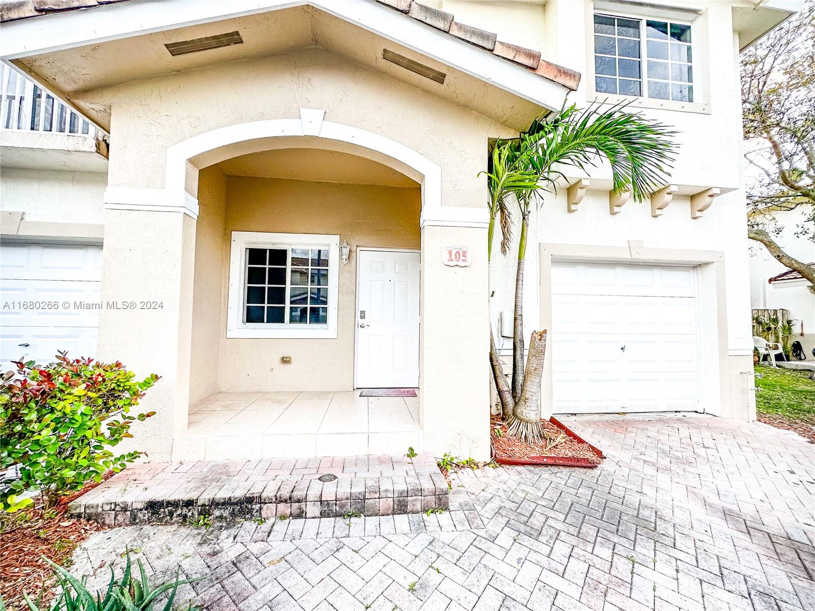 13970 Southwest 260th Street, Unit 105 Homestead, FL 33032 - Photo 2 of 31 a front view of a house with a yard