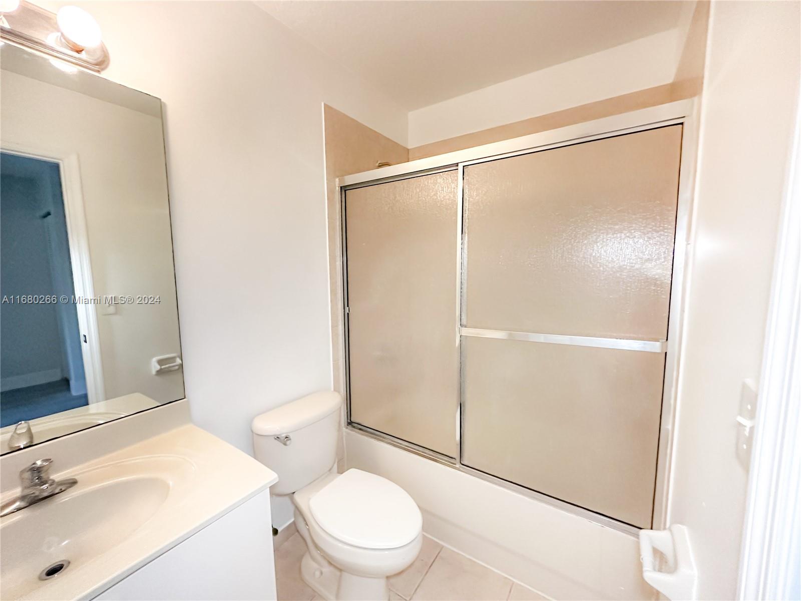 13970 Southwest 260th Street, Unit 105 Homestead, FL 33032 - Photo 22 of 31 a bathroom with a sink mirror vanity and toilet