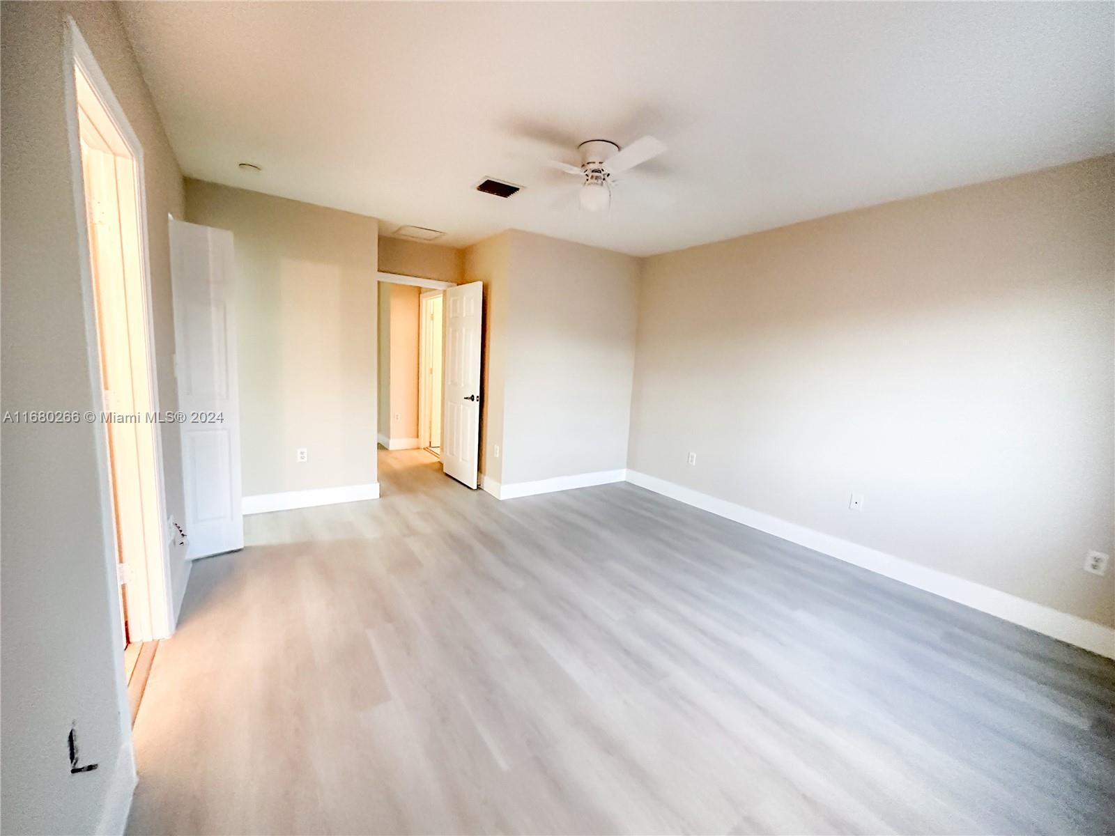 13970 Southwest 260th Street, Unit 105 Homestead, FL 33032 - Photo 27 of 31 a view of an empty room with wooden floor and a window