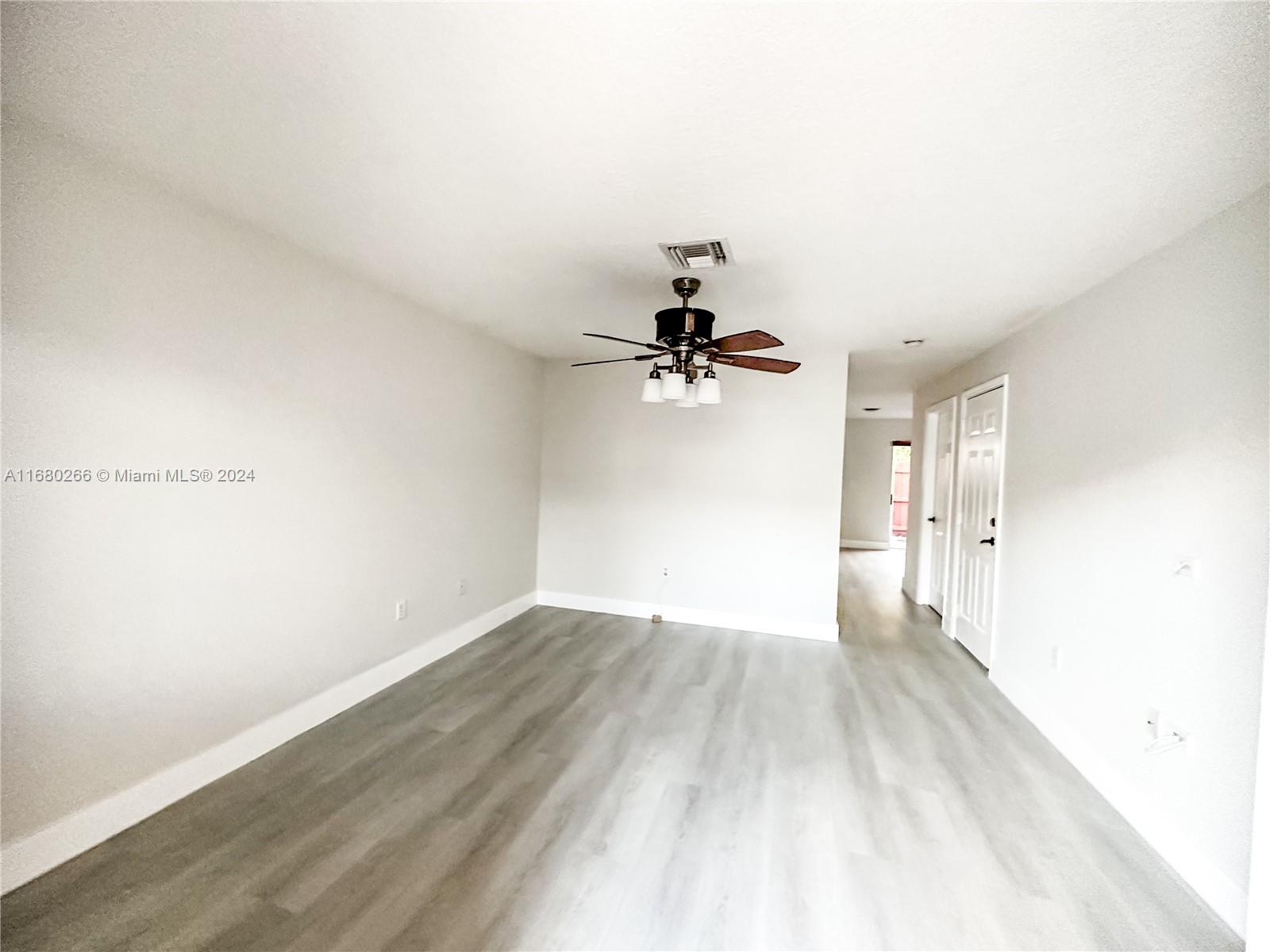 13970 Southwest 260th Street, Unit 105 Homestead, FL 33032 - Photo 3 of 31 a view of a room with wooden floor