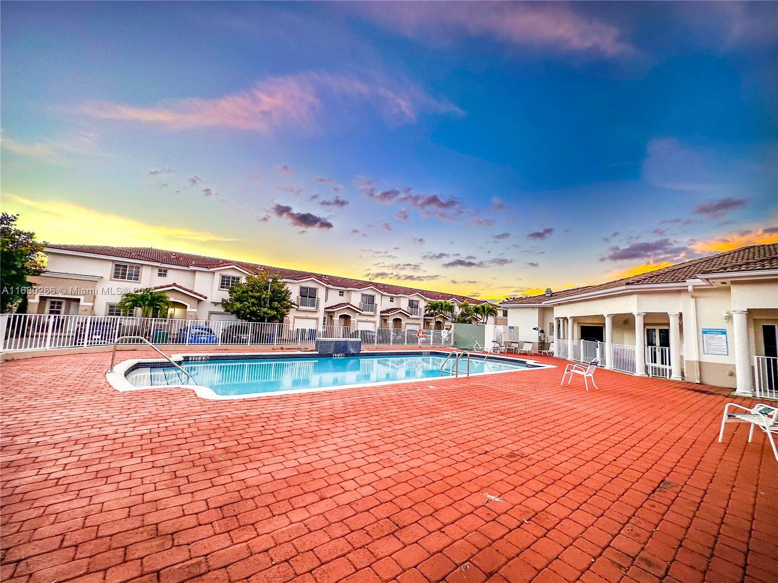 13970 Southwest 260th Street, Unit 105 Homestead, FL 33032 - Photo 31 of 31 a view of a swimming pool with an outdoor space and seating area