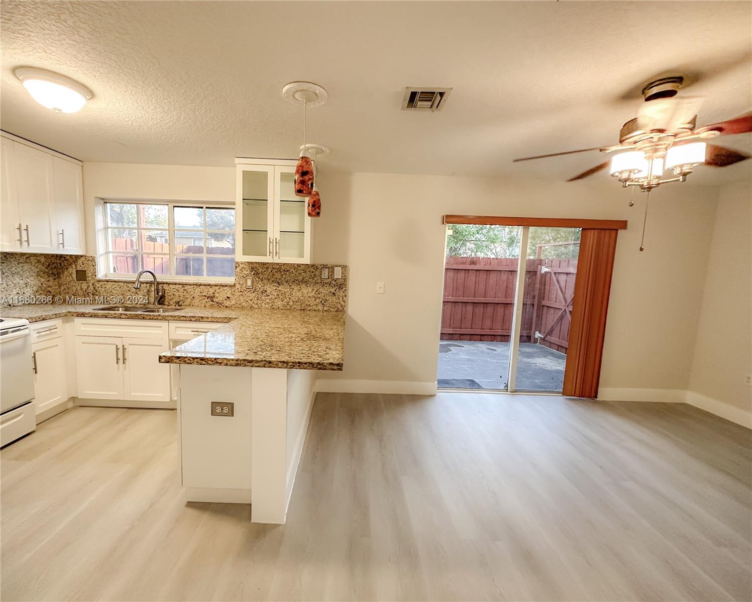 13970 Southwest 260th Street, Unit 105 Homestead, FL 33032 - Photo 10 of 31 a kitchen with granite countertop a stove a sink and a refrigerator