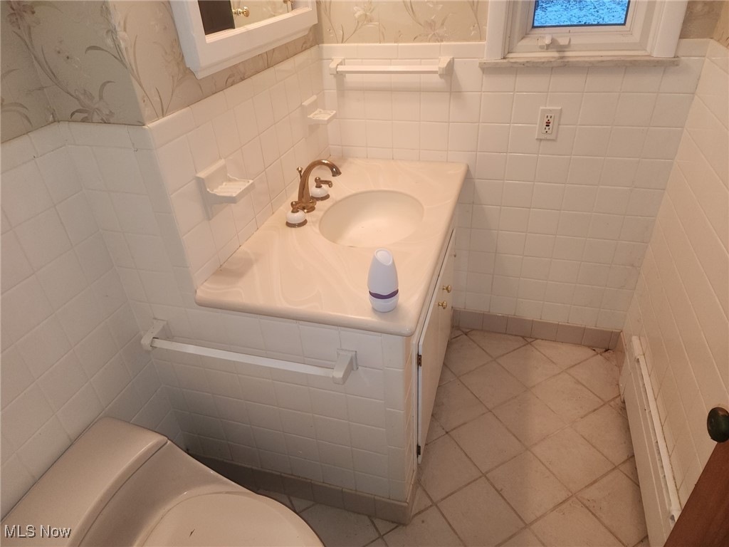 7516 Mayfield Road Chesterland, OH 44026 - Photo 8 of 21 Half bath featuring wainscoting, vanity, and wallpapered walls