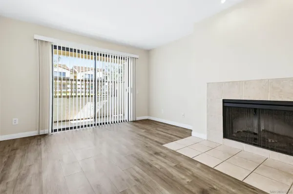 an empty room with wooden floor and fireplace