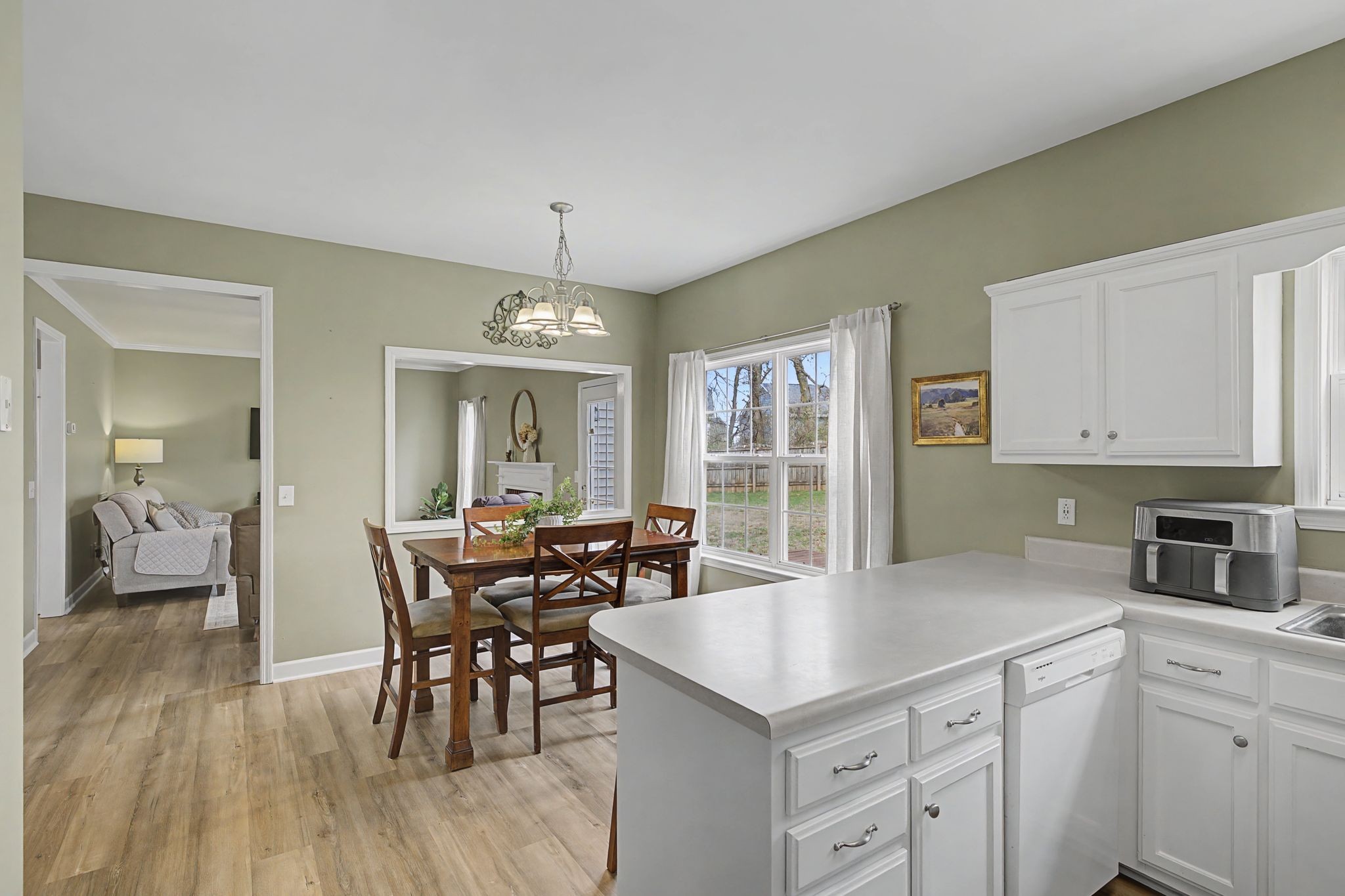 4012 Farmville Court Spring Hill, TN 37174 - Photo 15 of 29 a kitchen with stainless steel appliances granite countertop a stove a refrigerator a sink a dining table and chairs with wooden floor