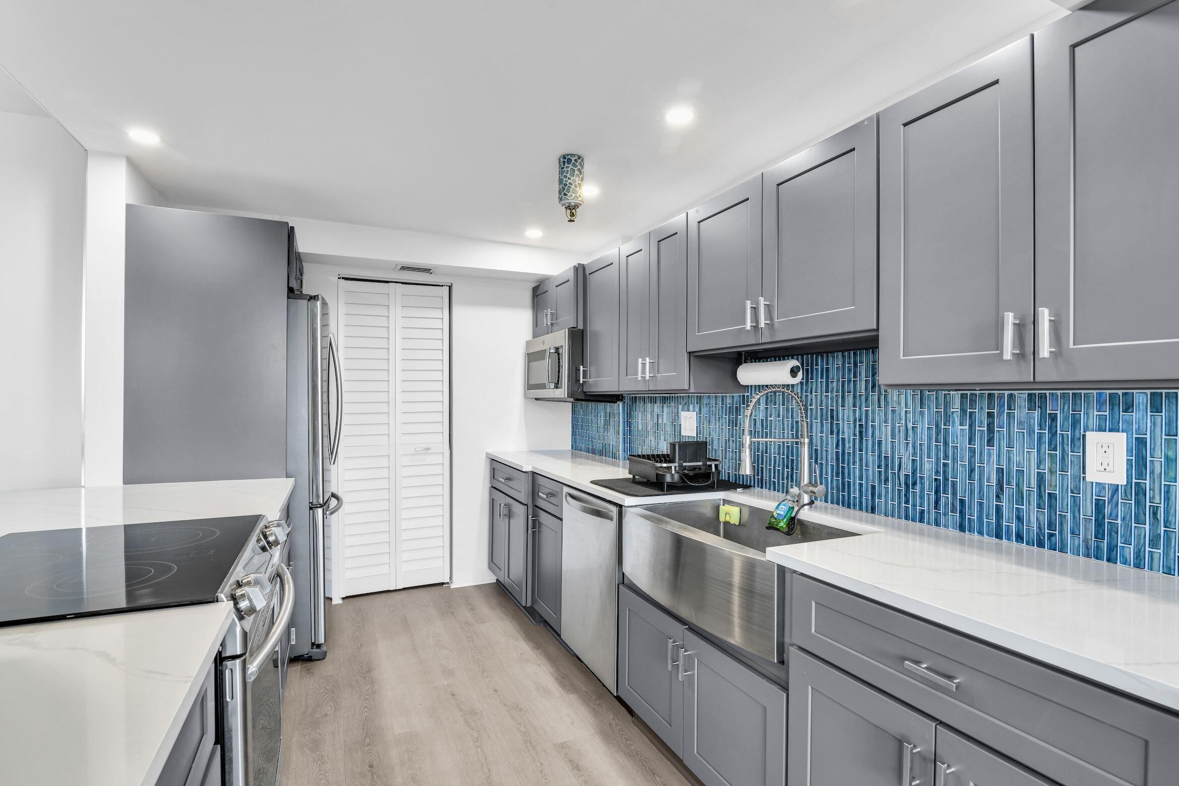 859 Jeffery Street, Unit 5090 Boca Raton, FL 33487 - Photo 4 of 55 a kitchen with granite countertop a sink stainless steel appliances and cabinets