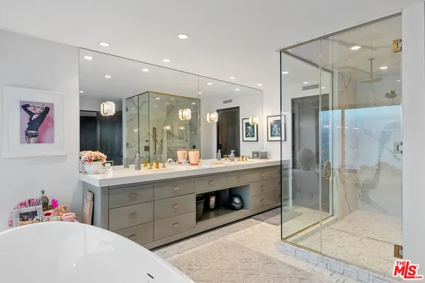 a view of a bathroom sink mirror and shower