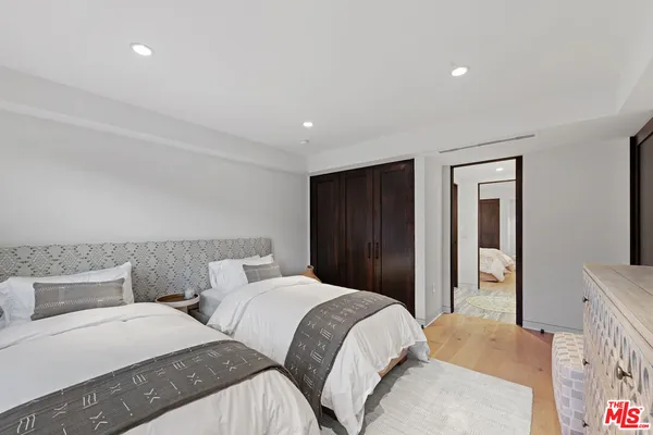 a bedroom with two beds and a dresser