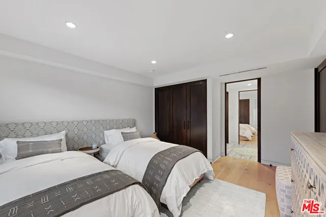 a bedroom with two beds and a dresser