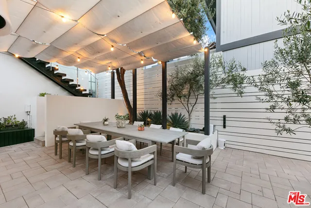 a view of a patio with table and chairs and potted plants