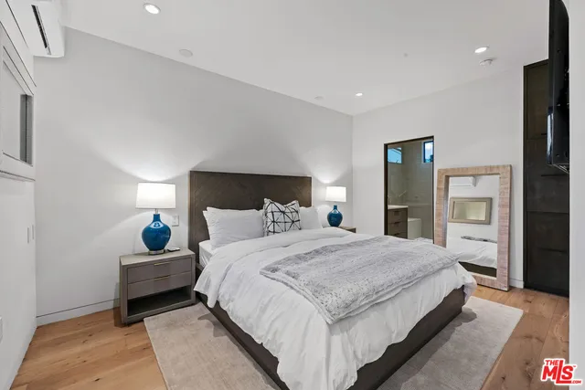 a bedroom with a bed and wooden floor