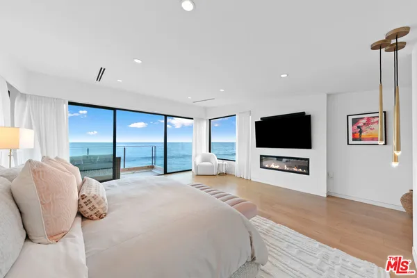 a large bedroom with a bed and a flat screen tv