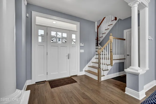 a view of a hallway with wooden floor and staircase