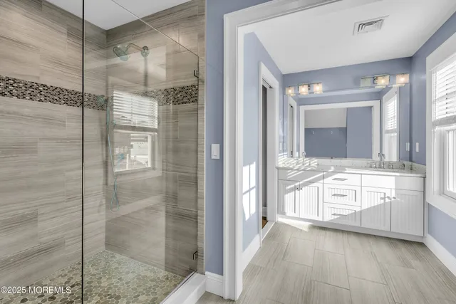 a bathroom with a granite countertop sink mirror and shower
