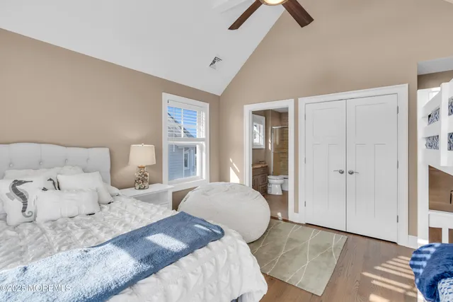 a bedroom with a large bed and a chandelier fan