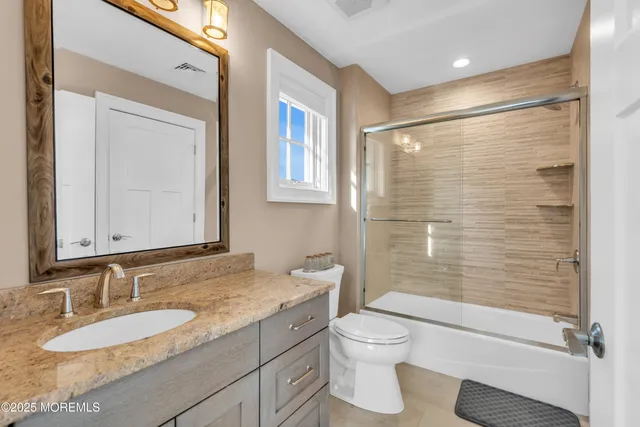 a bathroom with a granite countertop sink toilet and shower