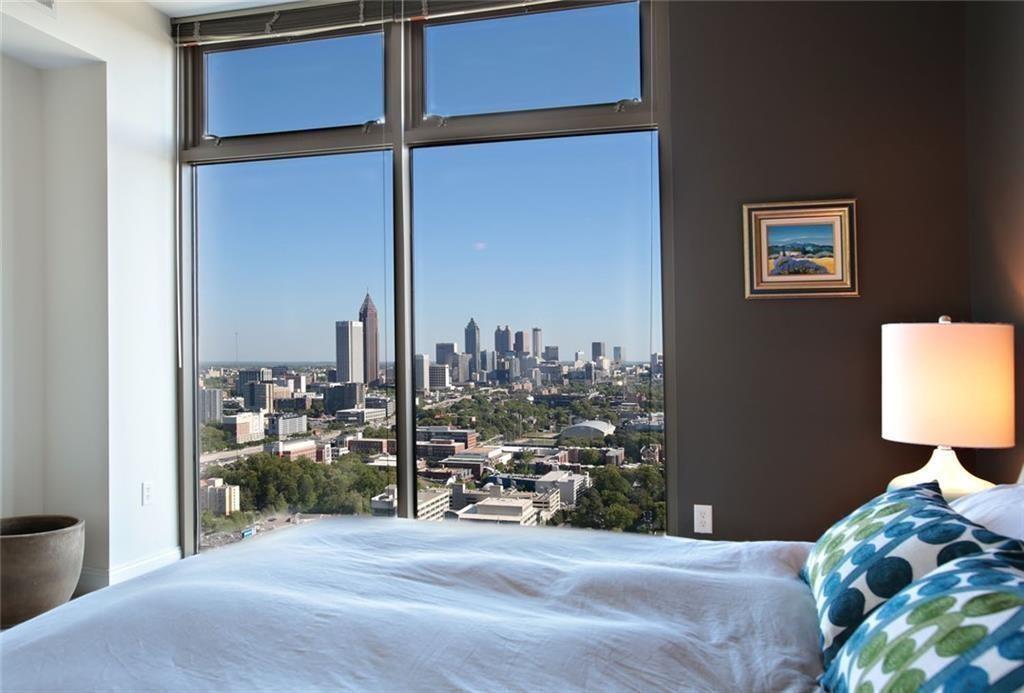 270 17th Street Northwest, Unit 4201 Atlanta, GA 30363 - Photo 11 of 23 a bedroom with a bed and a lamp on table