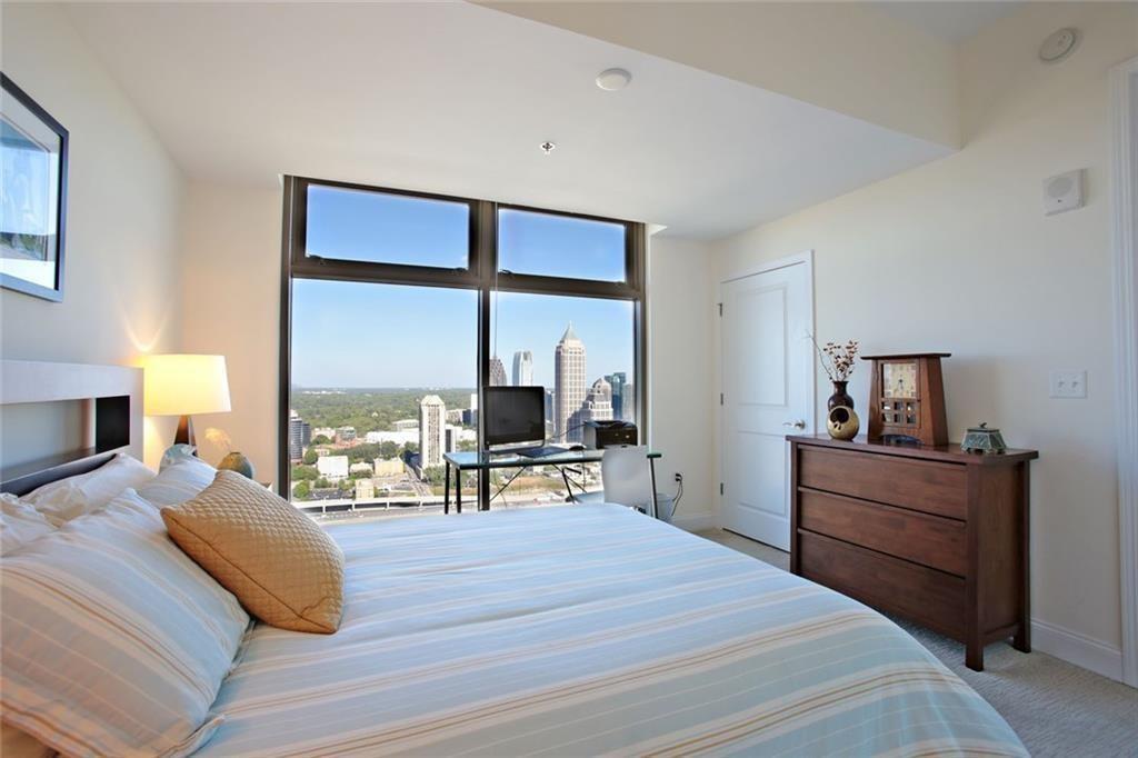 270 17th Street Northwest, Unit 4201 Atlanta, GA 30363 - Photo 16 of 23 a bedroom with a bed and large windows