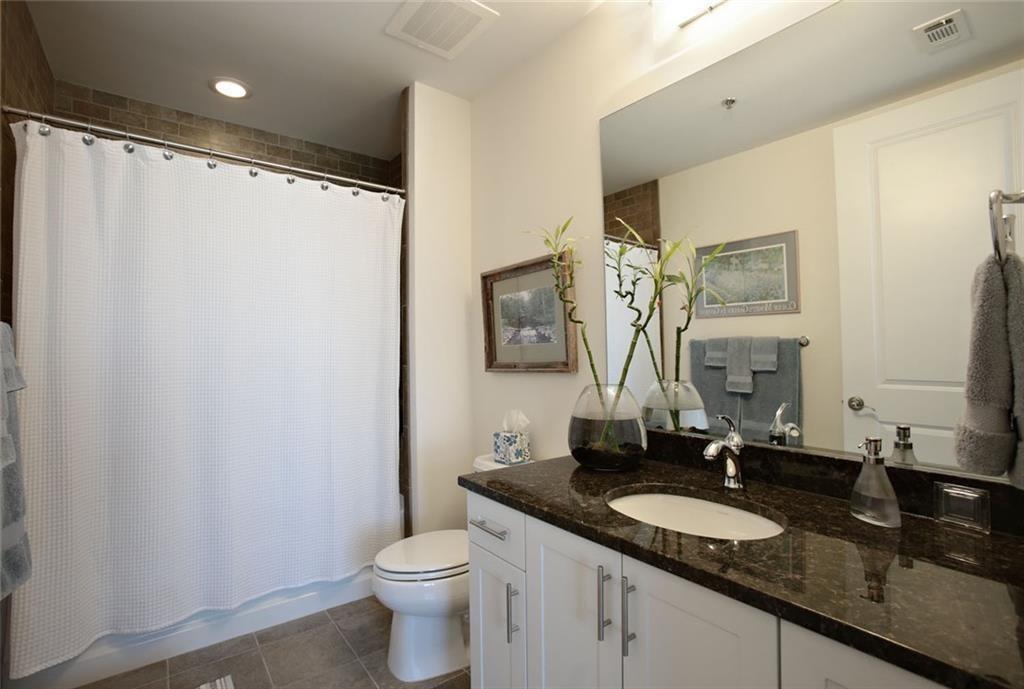 270 17th Street Northwest, Unit 4201 Atlanta, GA 30363 - Photo 17 of 23 a bathroom with a granite countertop sink and a mirror