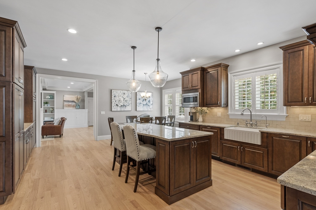 26 Mill Pond Road Bolton, MA 01740 - Photo 3 of 42 a dining hall with stainless steel appliances granite countertop a sink dishwasher a dining table and chairs with wooden floor