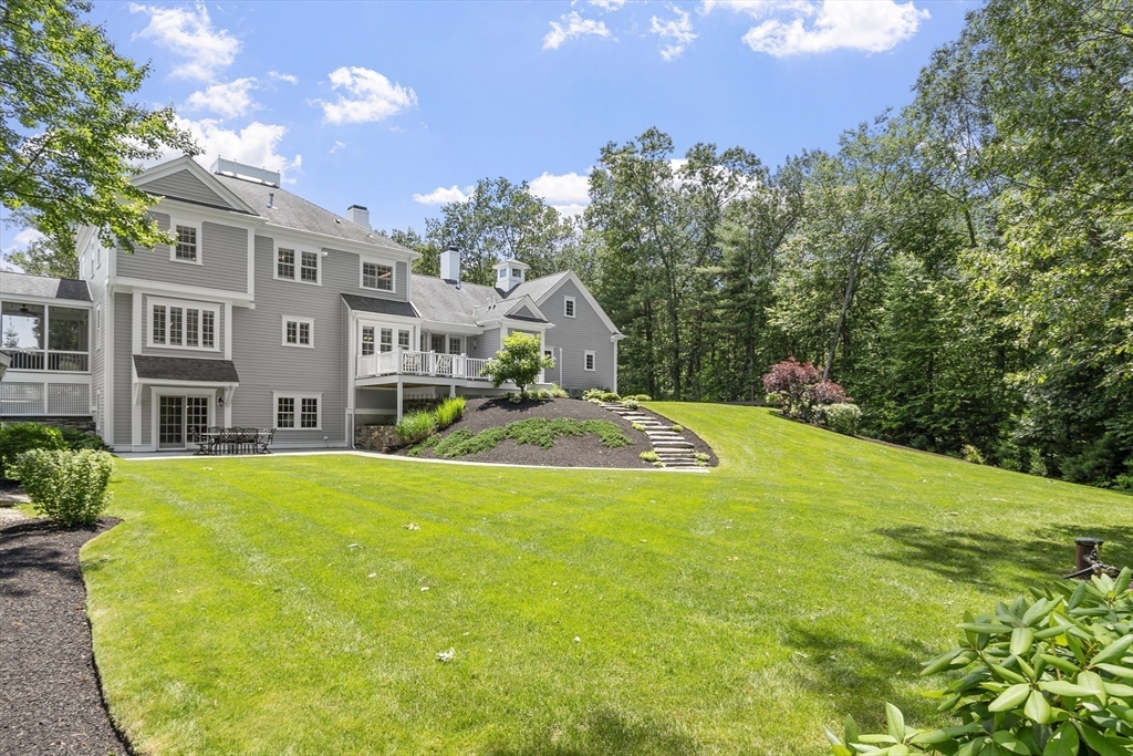 26 Mill Pond Road Bolton, MA 01740 - Photo 37 of 42 a view of a house with pool and trees in the background