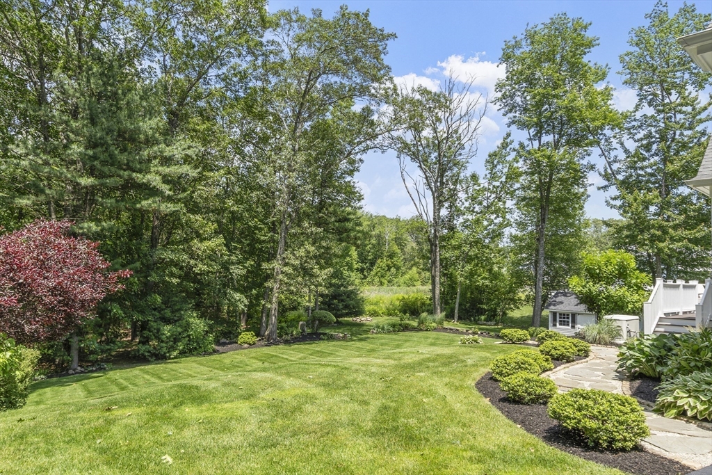 26 Mill Pond Road Bolton, MA 01740 - Photo 40 of 42 a backyard of a house with trees and entertaining space