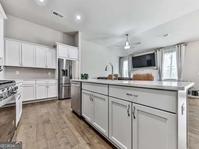 a kitchen with white cabinets and white appliances