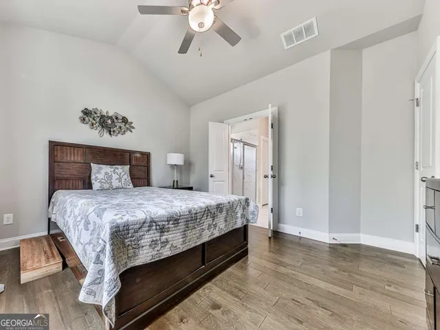 a bedroom with bed and wooden floor