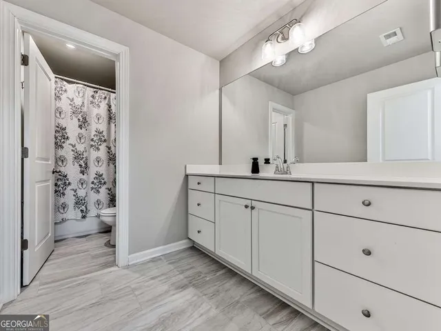 a bathroom with a double vanity sink mirror and shower