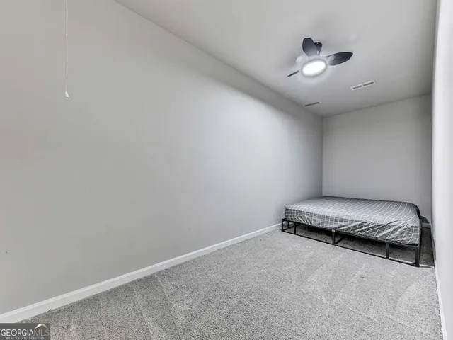 an empty room with a chandelier fan