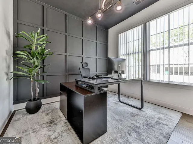 a living room with stainless steel appliances kitchen island granite countertop a stove a sink and a potted plant