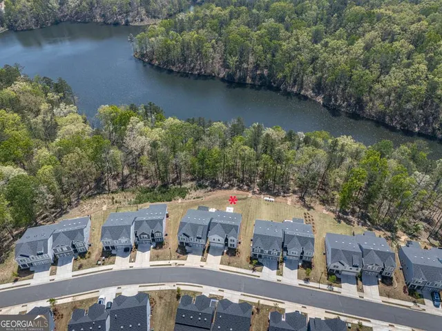 an aerial view of residential houses with outdoor space and lake view