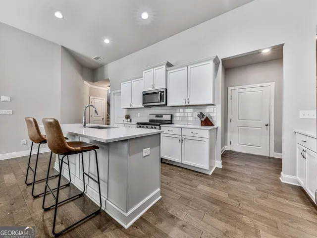 a kitchen with a sink cabinets and wooden floor