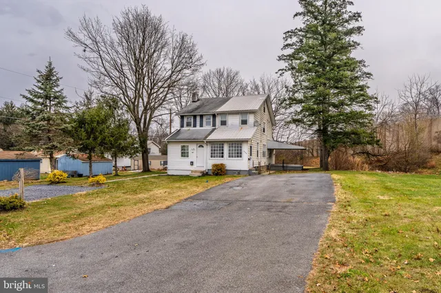 a front view of a house with a yard and trees