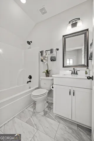a bathroom with a toilet a sink a mirror and bathtub