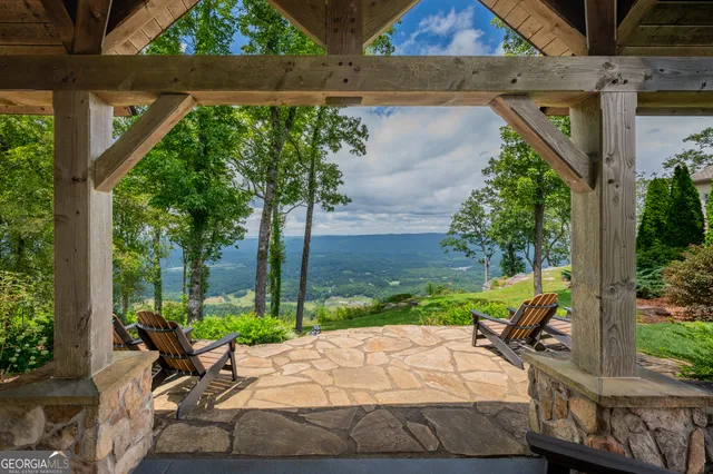 a view of a backyard with couches under an umbrella
