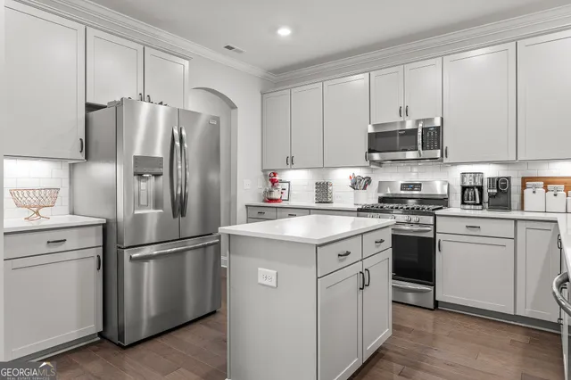 a kitchen with appliances a sink and cabinets