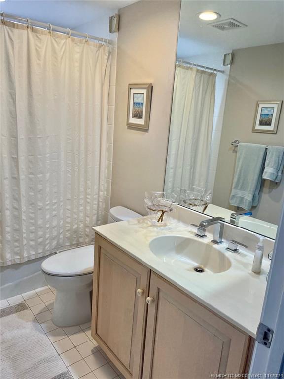 579 Northeast Plantation Road, Unit 301N Jensen Beach, FL 34957 - Photo 12 of 15 a bathroom with a sink toilet and mirror