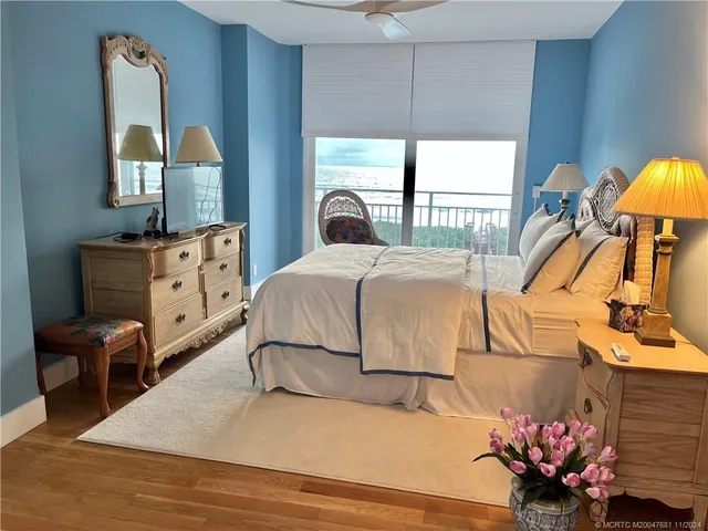 a bedroom with a bed and a large mirror on the dresser