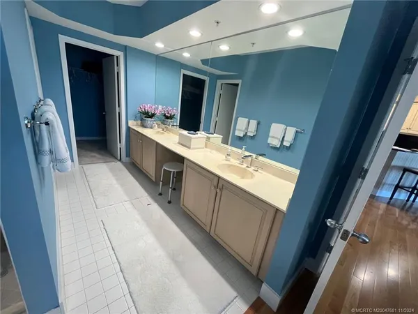 a spacious bathroom with a double vanity sink a toilet a mirror and vanity