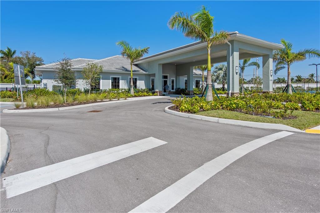 1093 Tranquil Brook Drive Naples, FL 34114 - Photo 20 of 22 a front view of a house with a garden and plants