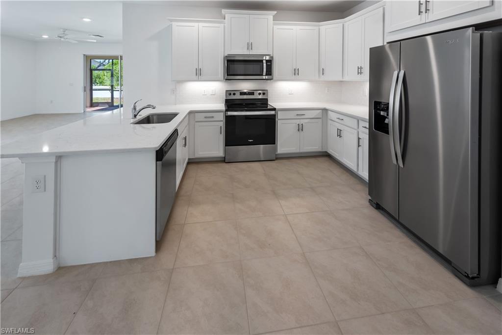 1093 Tranquil Brook Drive Naples, FL 34114 - Photo 7 of 22 a kitchen with a refrigerator sink and stove top oven
