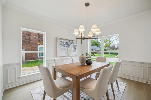 a view of a dining room with furniture a chandelier and wooden floor