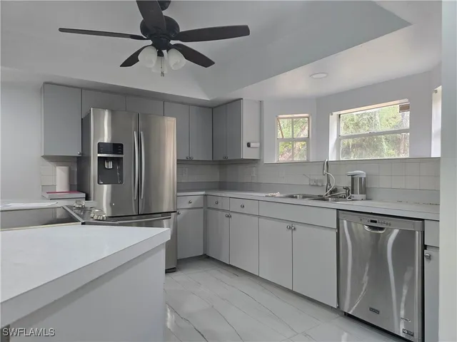 a kitchen with granite countertop a refrigerator and a stove top oven