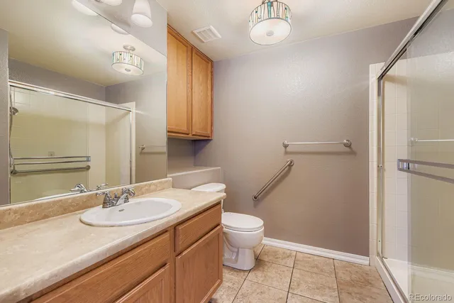 a bathroom with a granite countertop sink toilet and shower
