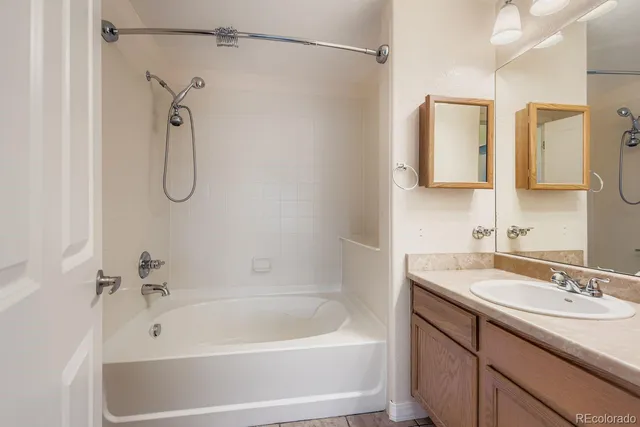 a bathroom with a tub a sink and a shower
